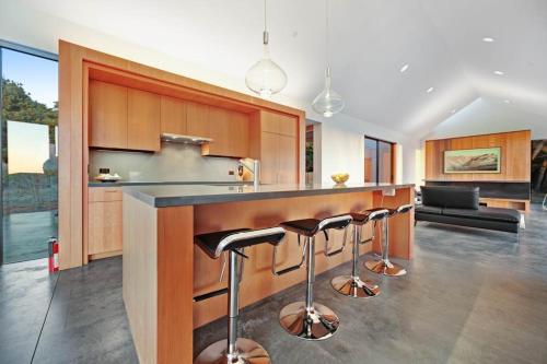 a kitchen with a counter with bar stools at Sky Fall in Sea Ranch
