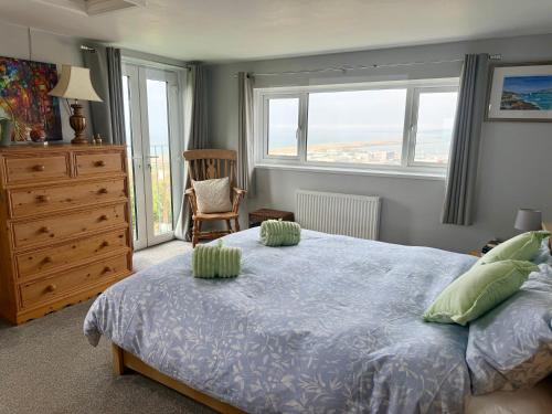 a bedroom with a bed and a dresser and windows at Dream view holiday home in Castletown