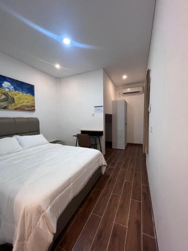 a bedroom with a bed and a desk in it at The Haven Suites Batam in Tanjunguma