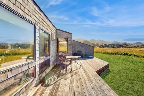 a wooden deck with a table and chairs on a house at Albatross Reach in Sea Ranch