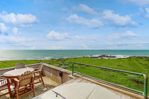 a balcony with a table and chairs and the ocean at Compass Rose in Sea Ranch