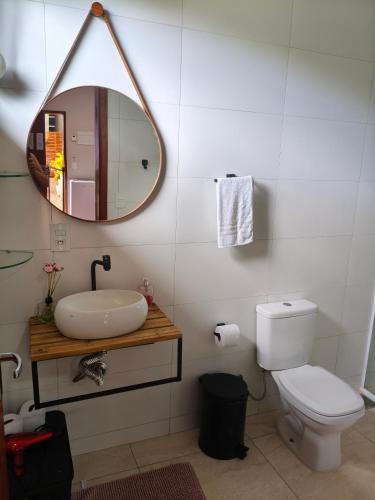 a bathroom with a sink and a mirror and a toilet at REFUGIO Chacara ENTRE NÓS in Holambra