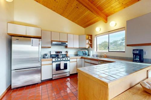 a kitchen with white appliances and a wooden ceiling at Whispering Wave in Gualala