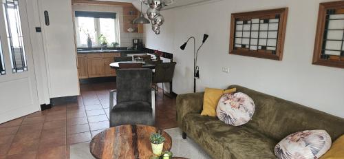 a living room with a couch and a table at Spekenbrink-Haaksbergen in Haaksbergen