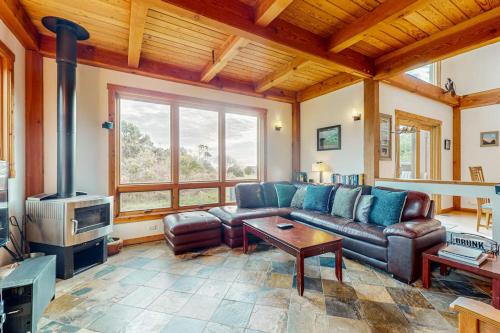 a living room with a leather couch and a fireplace at The Barn in Gualala
