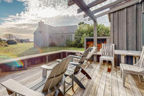 a deck with chairs and a table and a house at The Barn in Gualala
