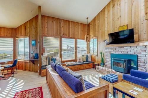 a living room with wooden walls and a fireplace at Clemons' Cottage in Sea Ranch