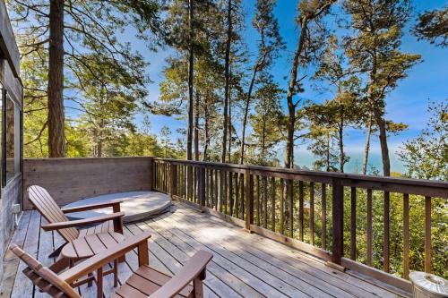 a wooden deck with chairs and a table at Redwood Grove in Sea Ranch