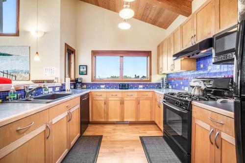 a kitchen with wooden cabinets and a black stove top oven at Ascona House in Sea Ranch