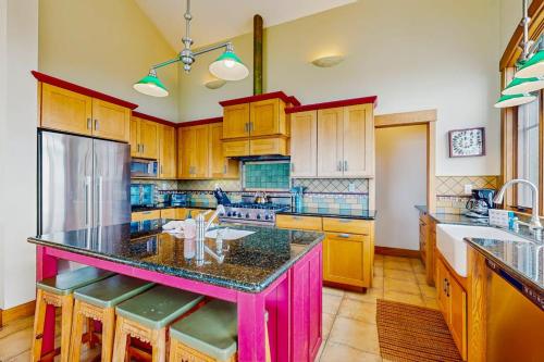 a kitchen with wooden cabinets and a pink island with bar stools at Seascape Gualala in Gualala