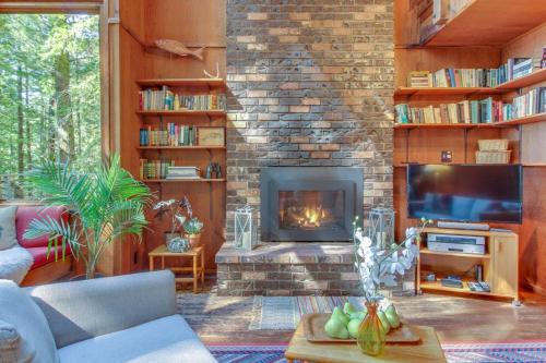 a living room with a fireplace and a tv at The Redwood House in Fish Rock
