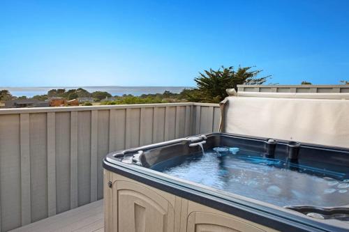 a hot tub on a balcony with the ocean in the background at Eternal Equinox in Sea Ranch