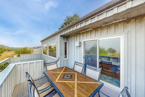 a patio with a table and chairs on a balcony at Eternal Equinox in Sea Ranch