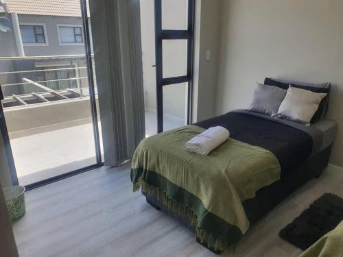 a bedroom with a bed with a ladder and a balcony at Crystal Self Catering 3 bedroom Villa in Swakopmund