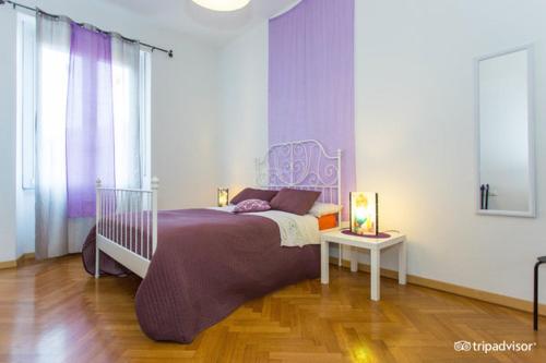 a bedroom with a purple bed and a table at Central Hostel Milano in Milan