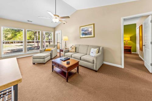 a living room with a couch and a table at Luxury Condo with Golf Course Views Pools & Resort Access in New Bern