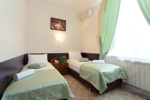 two beds in a small room with a window at Continental Hotel in Rostov on Don