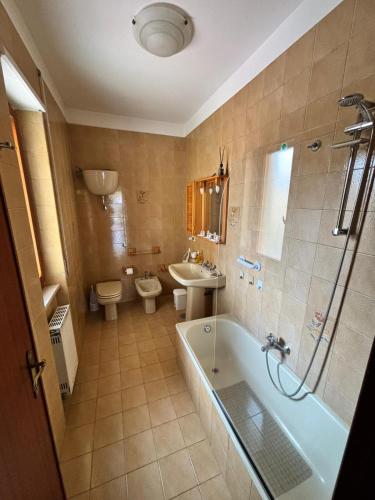 a bathroom with a tub and a toilet and a sink at Casa Pianforte - appartamento per vacanze in Bolsena
