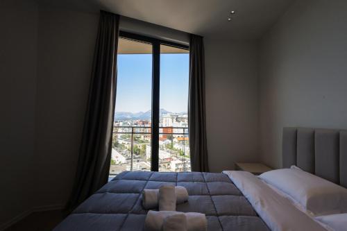 a bedroom with a bed and a large window at Giselle Escape in Tirana