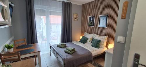 a small bedroom with a bed and a window at Idylla Apartamenty Gościnne blisko centrum in Kudowa-Zdrój