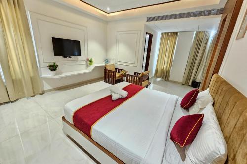 a bedroom with a large bed and a television at TrueLife Nexus Suites in Tirupati