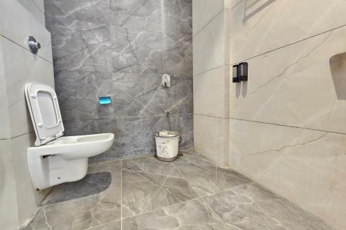 a bathroom with a toilet and a sink at TrueLife Nexus Suites in Tirupati
