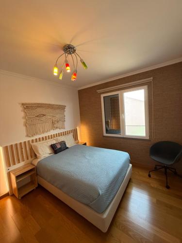 a bedroom with a bed and a ceiling fan at Tamariz Adventure - Sea View and Free Parking in Caniço