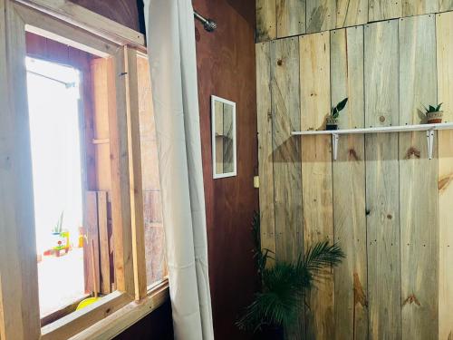 a room with a wooden wall and a window at Casa 74 hostel in Comitán