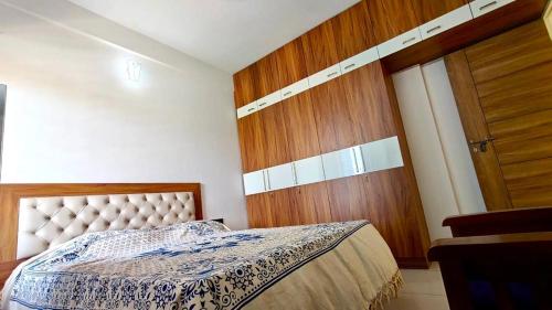 a bedroom with a bed and a wooden door at Sheetal Service Apartment in Mangalore