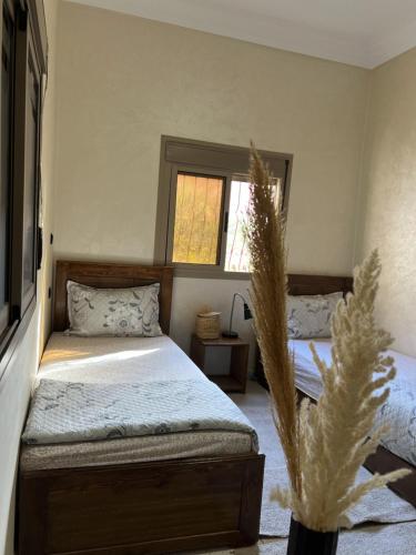 a bedroom with two beds and a window at Oasis apartment in Ouarzazate