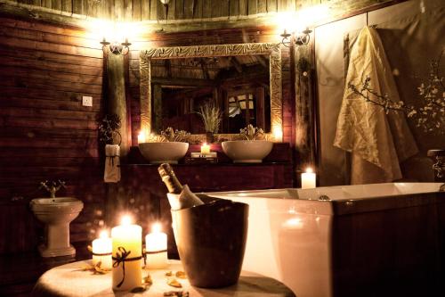 a bathroom with a tub with candles and a mirror at Mbali Mbali Soroi Serengeti Lodge in Banagi