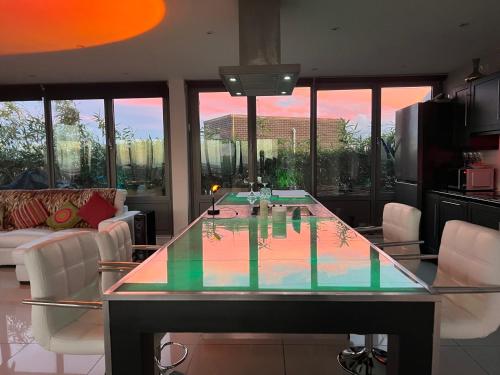 a large glass table in a living room with chairs at The London Skyline Penthouse in London