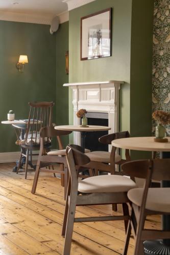 a room with tables and chairs and a fireplace at House Arundel in Arundel