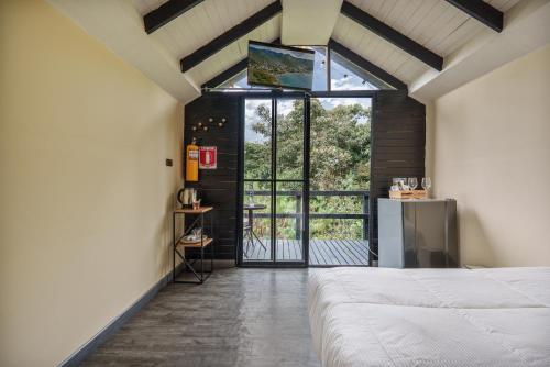a bedroom with a bed and an open door at Tiny House La Silleta in Medellín