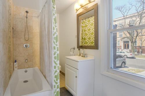 a bathroom with a tub and a sink and a window at Spacious Chicago Group Home! Walk to Train & Eats in Chicago