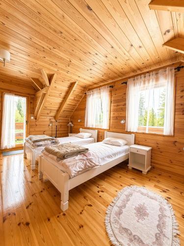 a bedroom with two beds in a wooden cabin at Guest house Mickovic in Žabljak