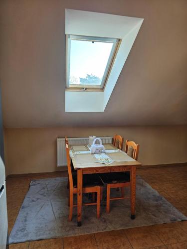 a table and chairs in a room with a window at Cudowne poddasze in Piotrków Trybunalski