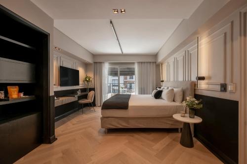 a bedroom with a bed and a desk and a television at CasaSur Recoleta in Buenos Aires