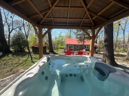 a hot tub in a backyard with a pergola at Spacious cabin w private river, hot tub & fire pit in Harpers Ferry