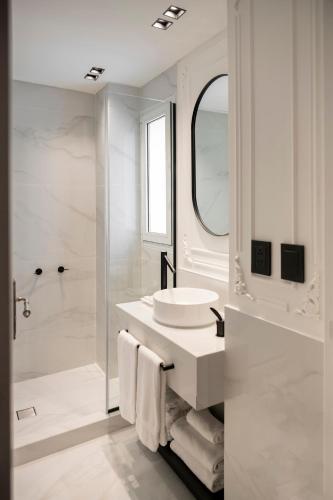 a white bathroom with a sink and a shower at CasaSur Recoleta in Buenos Aires