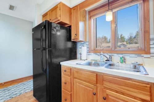 a kitchen with a black refrigerator and a sink at Chetola Cardinal 201 in Blowing Rock