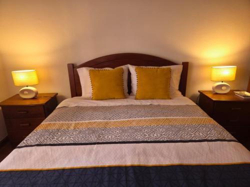 a bedroom with a bed with two lamps on tables at Casa Poço Azul in Achadinha