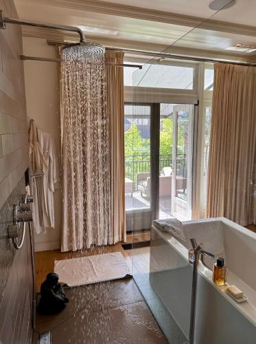 a bathroom with a tub and a large window at Boutique Home in Maassluis