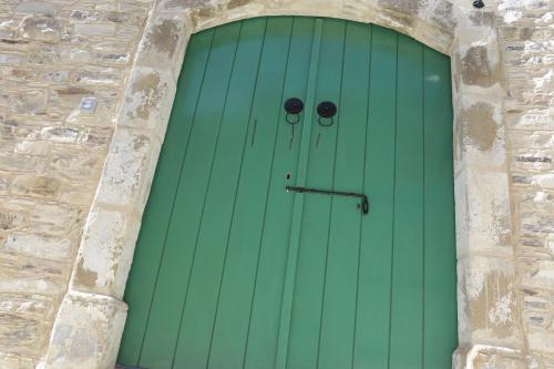 a green door in a stone wall at To Konatzi tis Marikas tzai tou Yianni in Kato Drys