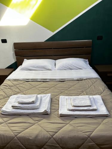 a bed with two towels on top of it at Appartamento Il Loftino in Forlì