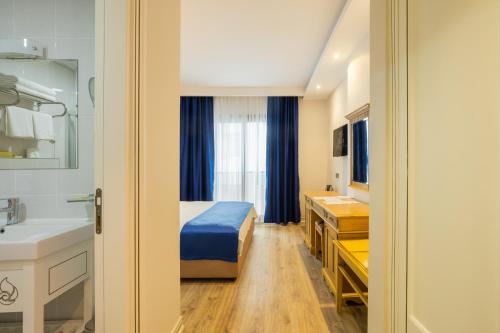 a room with a bed and a sink and a bathroom at Minerva Hotel Kızkalesi in Kizkalesi