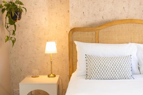 a bedroom with a bed with a lamp on a night stand at House Arundel in Arundel