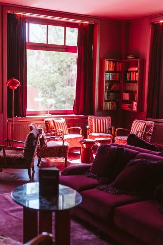 a living room with a couch and chairs and a window at Boutique Hotel Engadinerhof - A Home for Generations in Pontresina