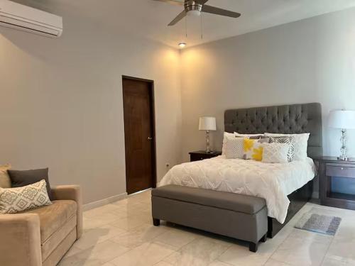 a bedroom with a bed and a chair and a couch at Increible Casa con vista al mar in La Paz