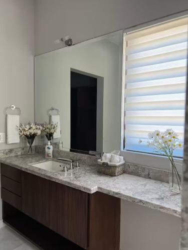 a bathroom with a sink and a large mirror at Increible Casa con vista al mar in La Paz